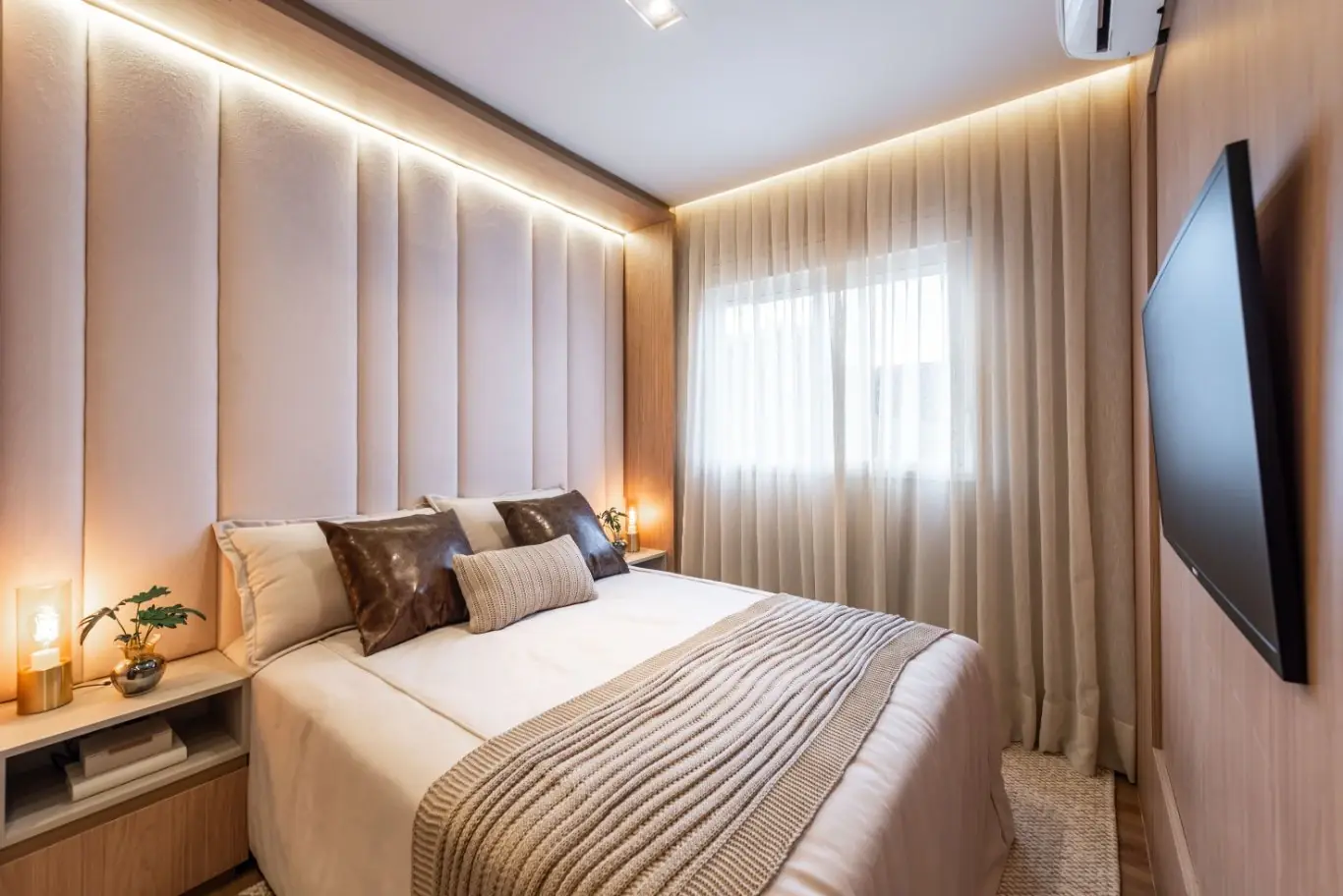 Dormitório de casal com cabeceira estofada e TV — Vision Campestre (decorado)