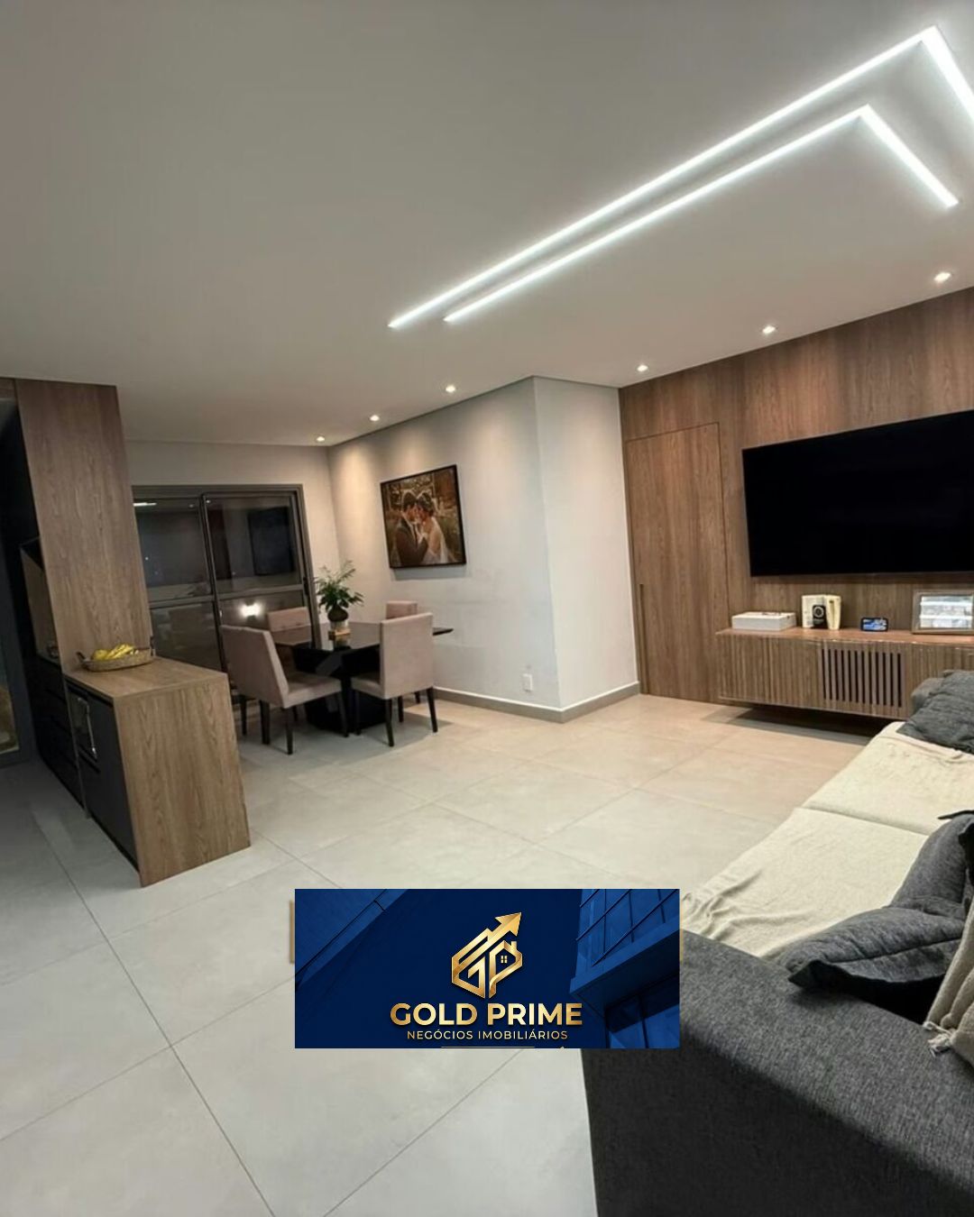 Sala ampla com painel de madeira, TV e mesa de jantar — Tatuapé