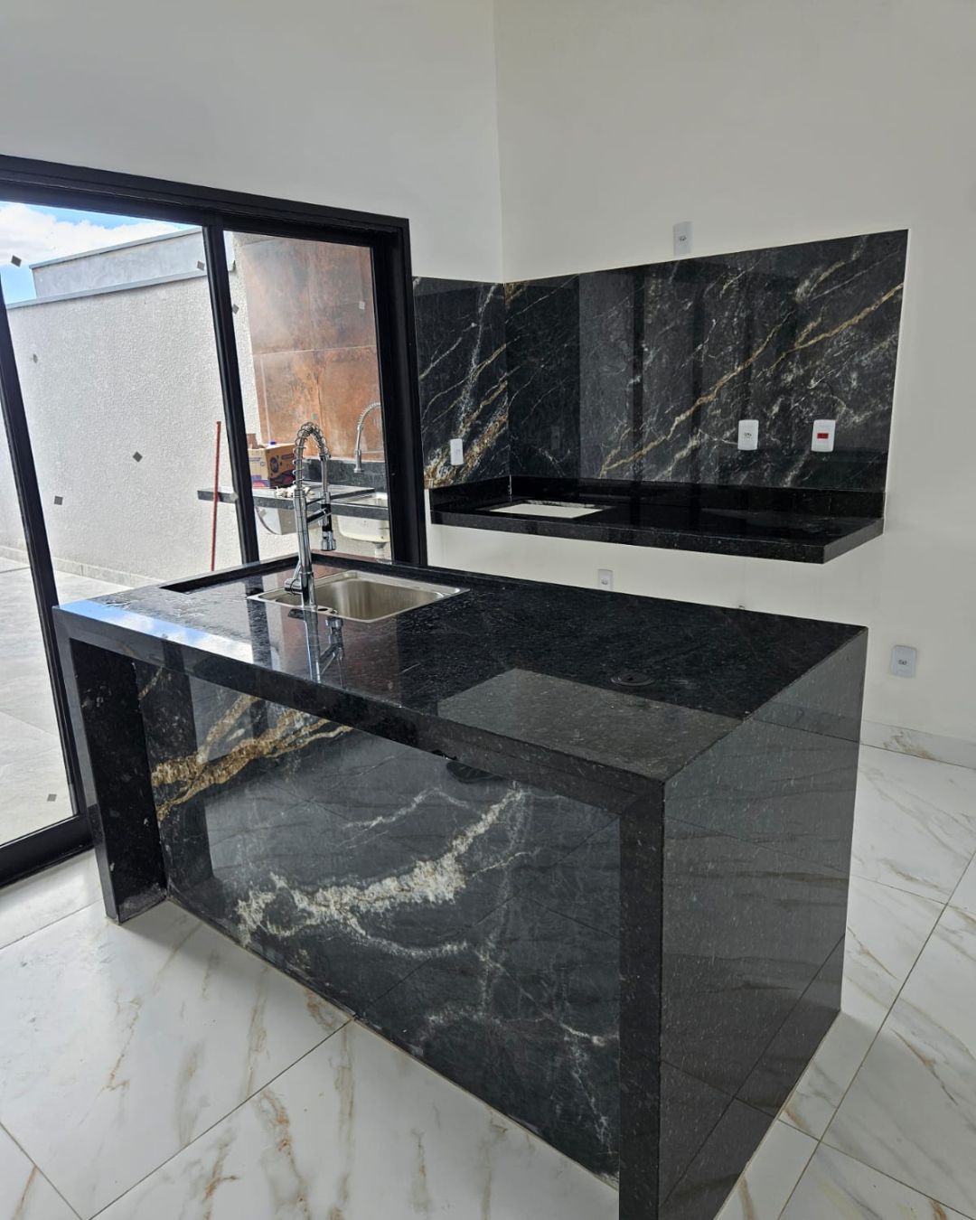 Área gourmet com bancada e painel de mármore preto — Bela Aliança, Campinas